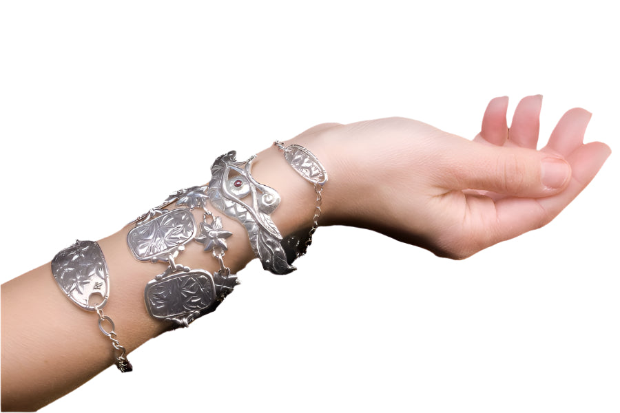 hand with a stack of silver bracelets